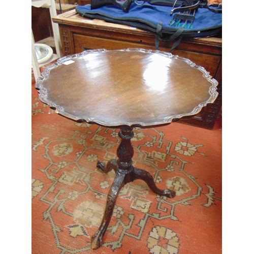 322 - Mahogany tripod table, tilt top with shaped rim, baluster column and on down swept supports. 25