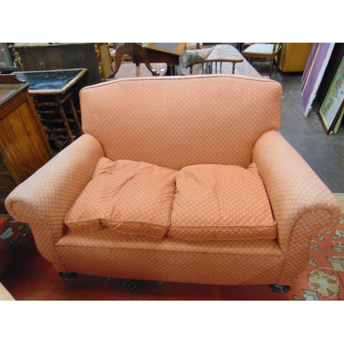 327 - Edwardian two seater settee, having all over upholstery, on bun feet and castors. 52