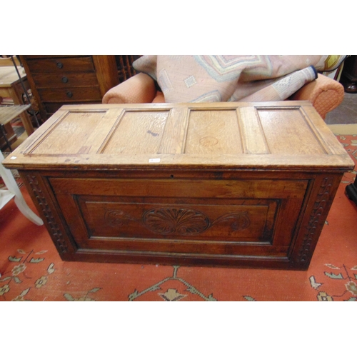 328 - An oak coffer, triple panel lift up top, carved front, on plain base. 24 x 47 x 20