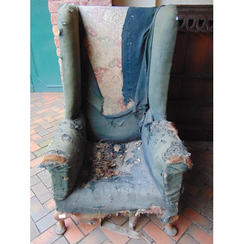 451 - Antique wingback armchair, set on short turned supports, for restoration.