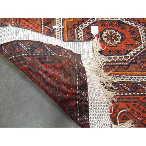 97 - Red ground Persian rug, having geometric pattern. 69 x 38