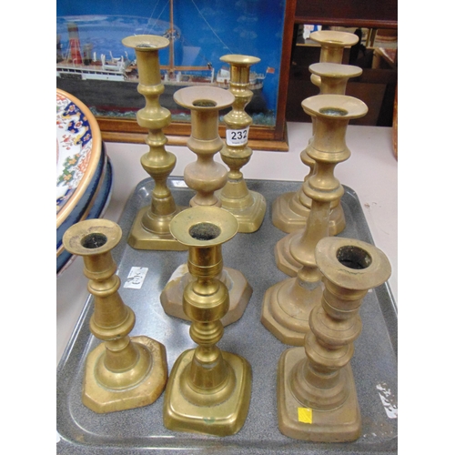 232 - Tray of brass candlesticks.