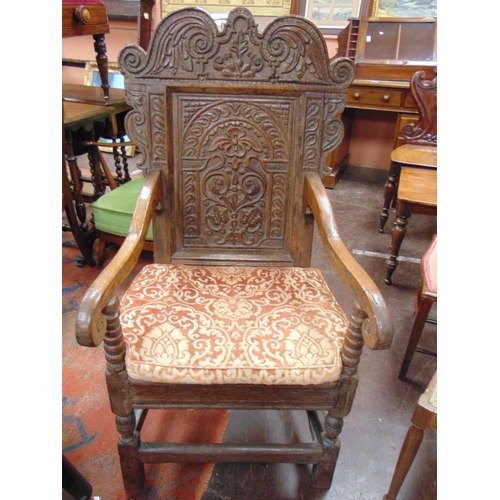 375 - Antique oak wainscot chair, shaped top above carved decoration, scroll arms, solid seat, set on balu... 