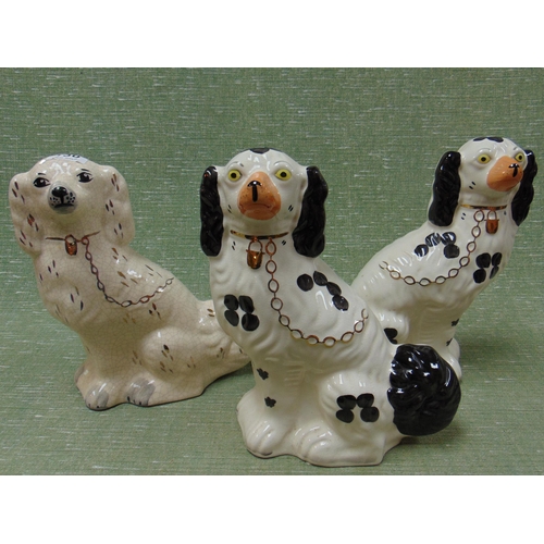 130 - Pair of black and white Staffordshire type spaniels and one other example.