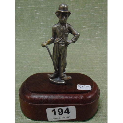 194 - Novelty plated figure, Charlie Chaplin, set on an oval wooden base, 6