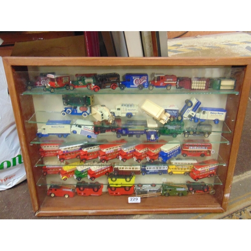 229 - Glazed wall cabinet, containing a quantity of collectable model vehicles.