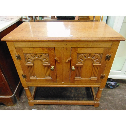 406 - An oak two door side cabinet, moulded decoration, on baluster turned supports joined by plain stretc... 