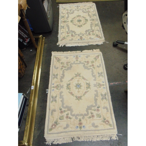 447 - Pair of cream coloured floral rugs, each 36 x 24