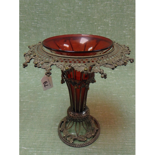 79 - Reproduction cranberry style glass vase, set on a shaped metal frame. 9.5