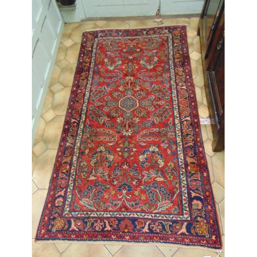 23 - Persian red ground rug, having geometric floral pattern, 77 x 39