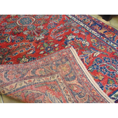 23 - Persian red ground rug, having geometric floral pattern, 77 x 39