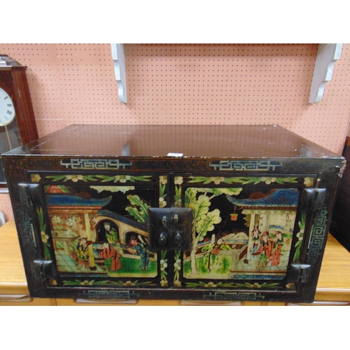 380 - An Oriental lacquered two door table top cabinet, having traditional decoration, 18 x 34 x 20