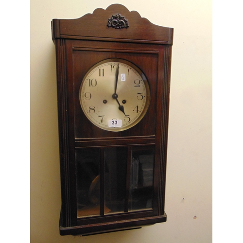 33 - An oak cased wall clock, having silvered dial and Arabic numerals.