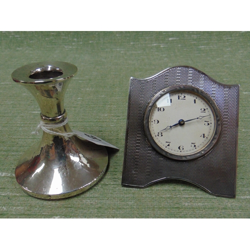 68 - Silver framed travel clock, together with a possibly silver filled silver squat candlestick. (2)