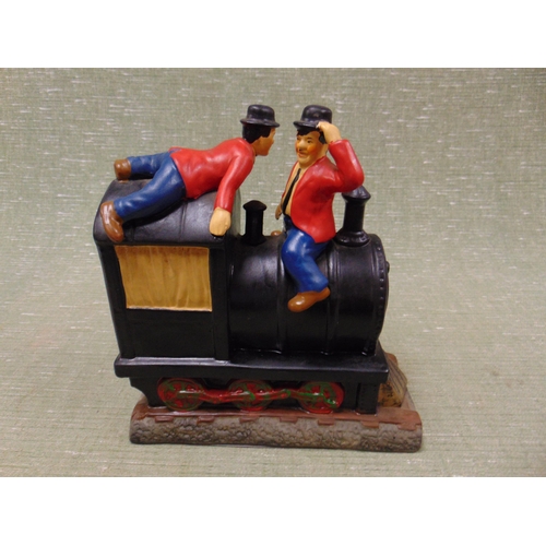 39 - Novelty painted chalk figure group, Laurel & Hardy sat atop a train.