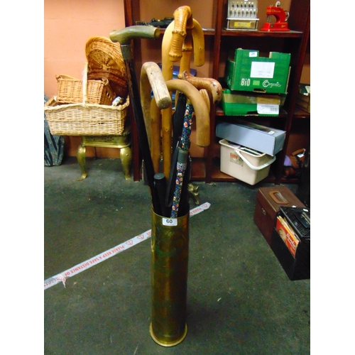 60 - Brass trench art stick stand, containing a collection of walking sticks.