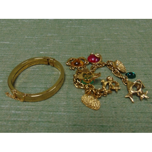 41 - Gold coloured charm bracelet and a gold coloured bangle. (2)