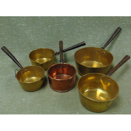 72 - Four antique brass saucepans and a copper example.