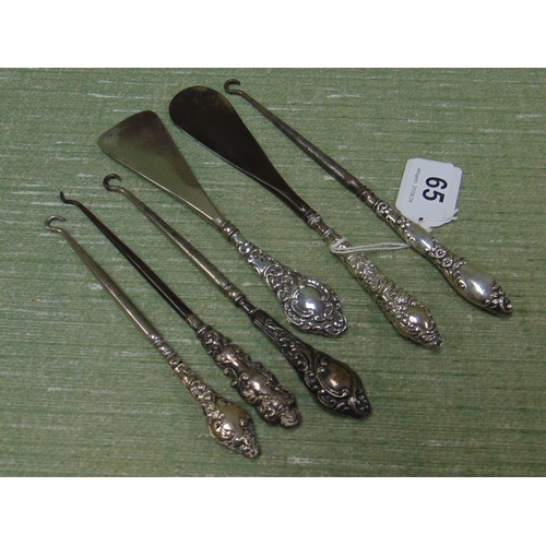 65 - Four silver handled button hooks and two silver handled shoe horns.