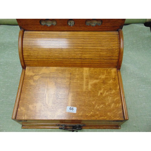 66 - Antique oak writing slope, the top having perpetual calendar, tambour front with pull out leather su... 