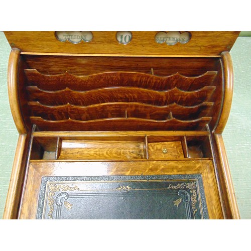 66 - Antique oak writing slope, the top having perpetual calendar, tambour front with pull out leather su... 