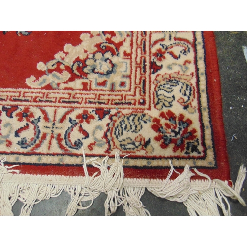 132 - Red and cream ground rug, having floral pattern, 66 x 45