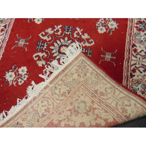 132 - Red and cream ground rug, having floral pattern, 66 x 45