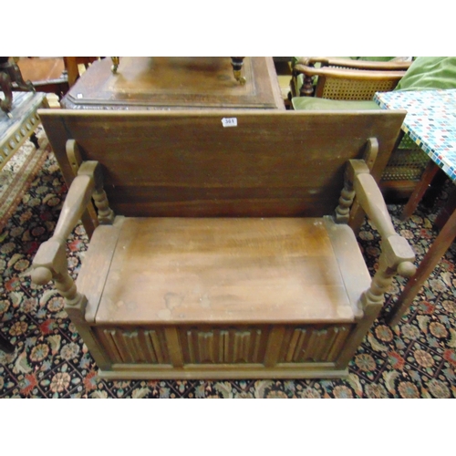 361 - An oak monk's bench, fold over top, open arms, lift up seat and linen fold decoration, 34