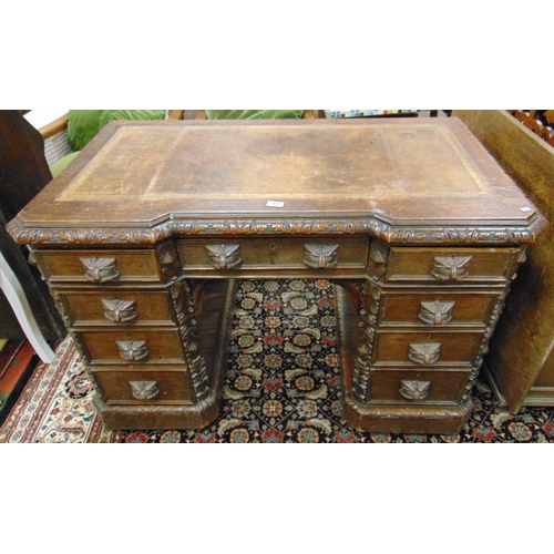 368 - An oak pedestal desk, inset leather top, inverted breakfront with all over Green Man carving, set on... 