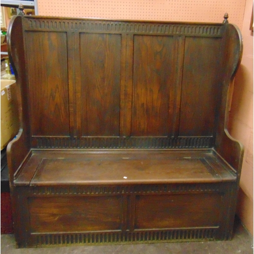 452 - An oak box settle, having wing back, quadruple panels, lift up seat and moulded decoration, 57 x 54 ... 