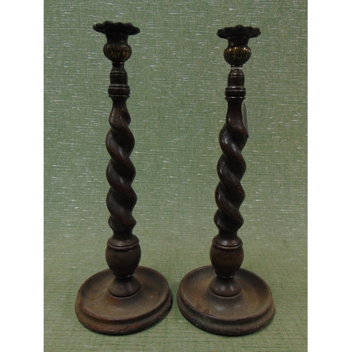 87 - Pair of oak barley twist candlesticks, each 14.5