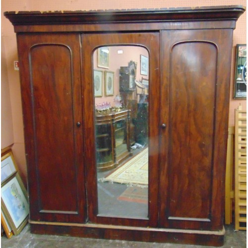 428 - Victorian mahogany triple door wardrobe, ogive cornice above centre mirror door, enclosing a fitted ... 