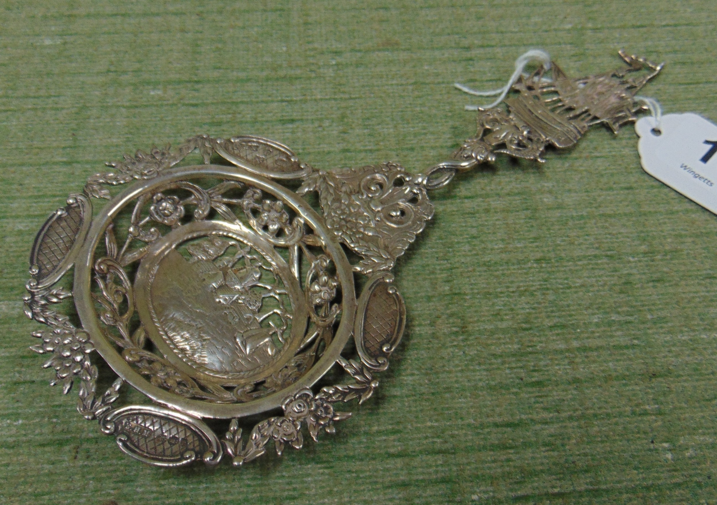 Silver tea strainer, having sailing vessel decoration.