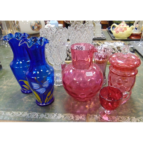 266 - Cranberry glass jug, lidded jar, pair of blue coloured glass vases, etc.