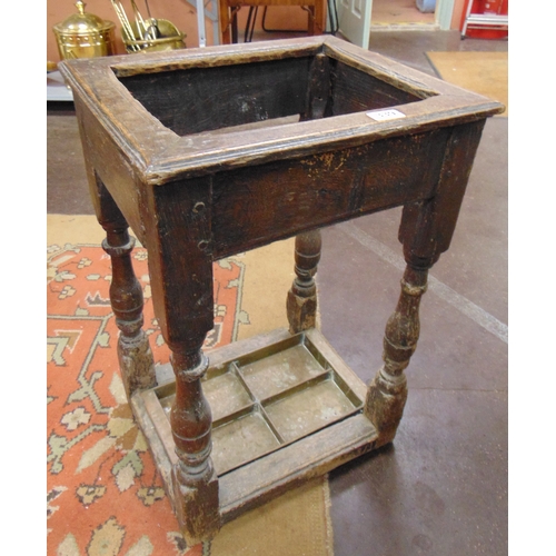 339 - An oak stick stand, set on baluster turned supports with drip tray to base, 25 x 17 x 13.5