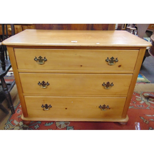 351 - Victorian pine chest of three long drawers with brass handles and escutcheons, set on bun feet, 31 x... 