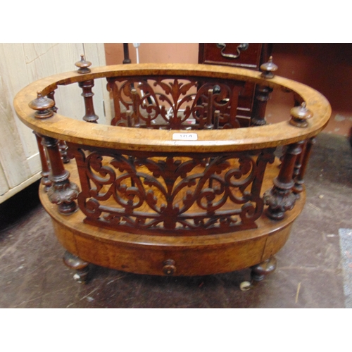 384 - Victorian walnut oval form canterbury, having fretwork decoration, single drawer, short mushroom cap... 