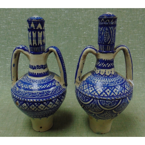 36 - Pair of blue and white two handled lidded Islamic vases, each 14