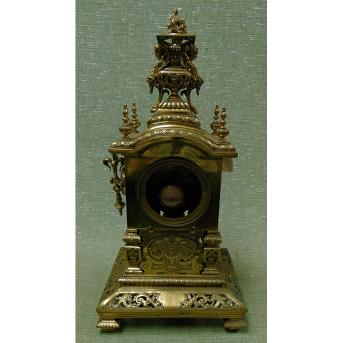 17 - Ornate antique brass mantle clock, having cherub form finial mounts, enamel Roman numerals, all over... 