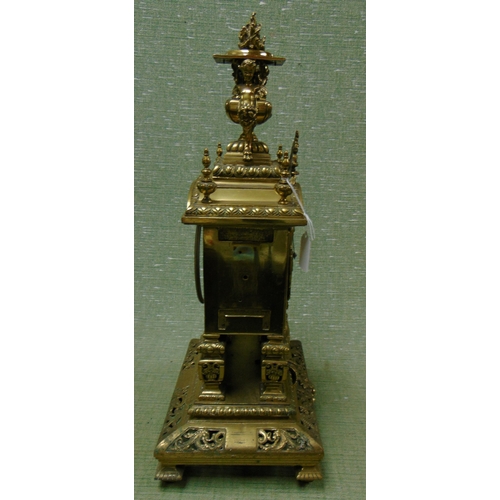 17 - Ornate antique brass mantle clock, having cherub form finial mounts, enamel Roman numerals, all over... 