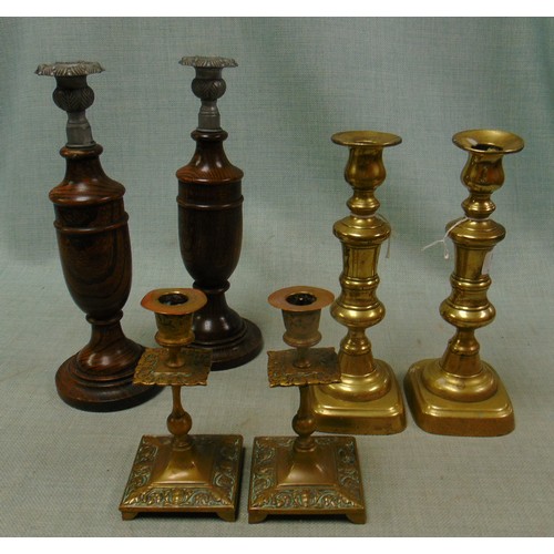 97 - Two pairs of brass candlesticks and an oak pair.