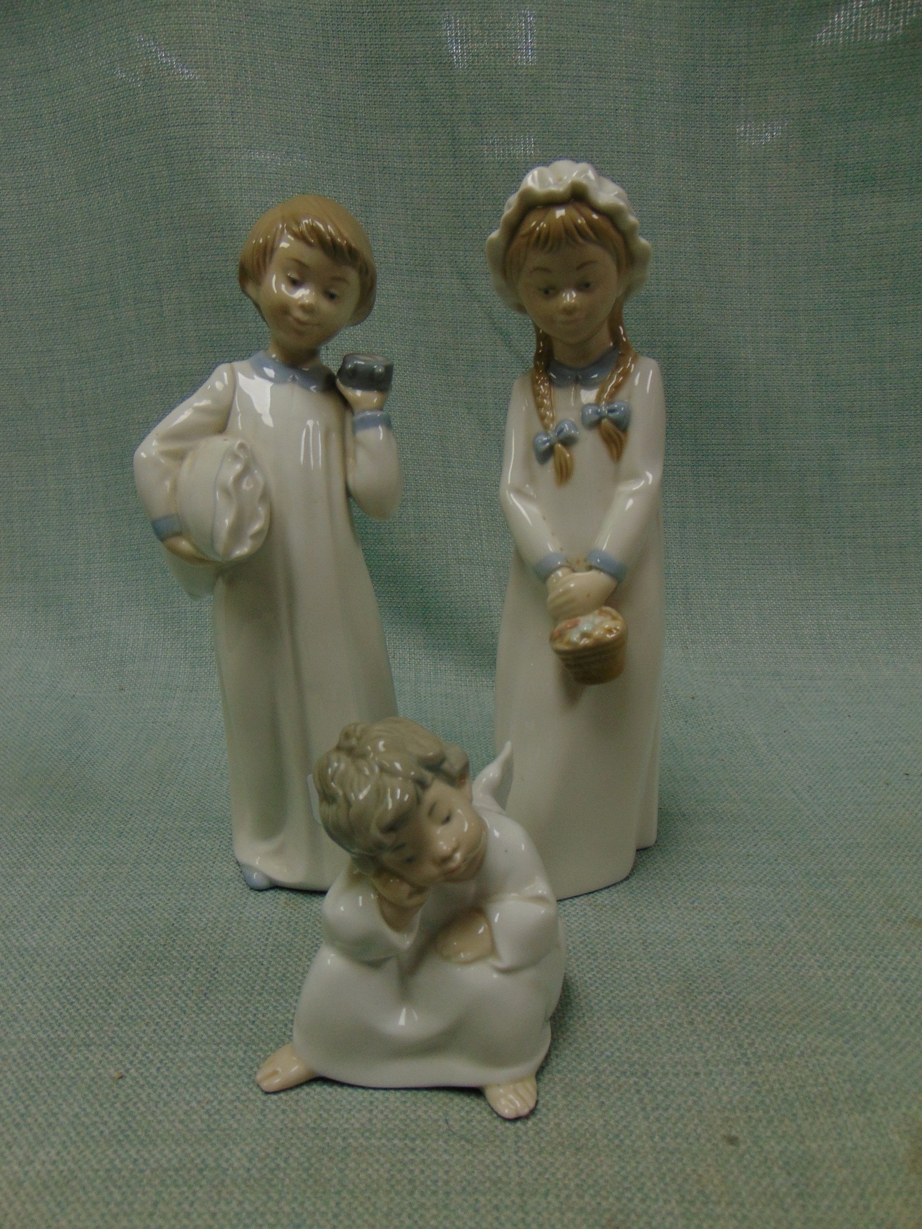 Two Nao figurines and a Lladro example.