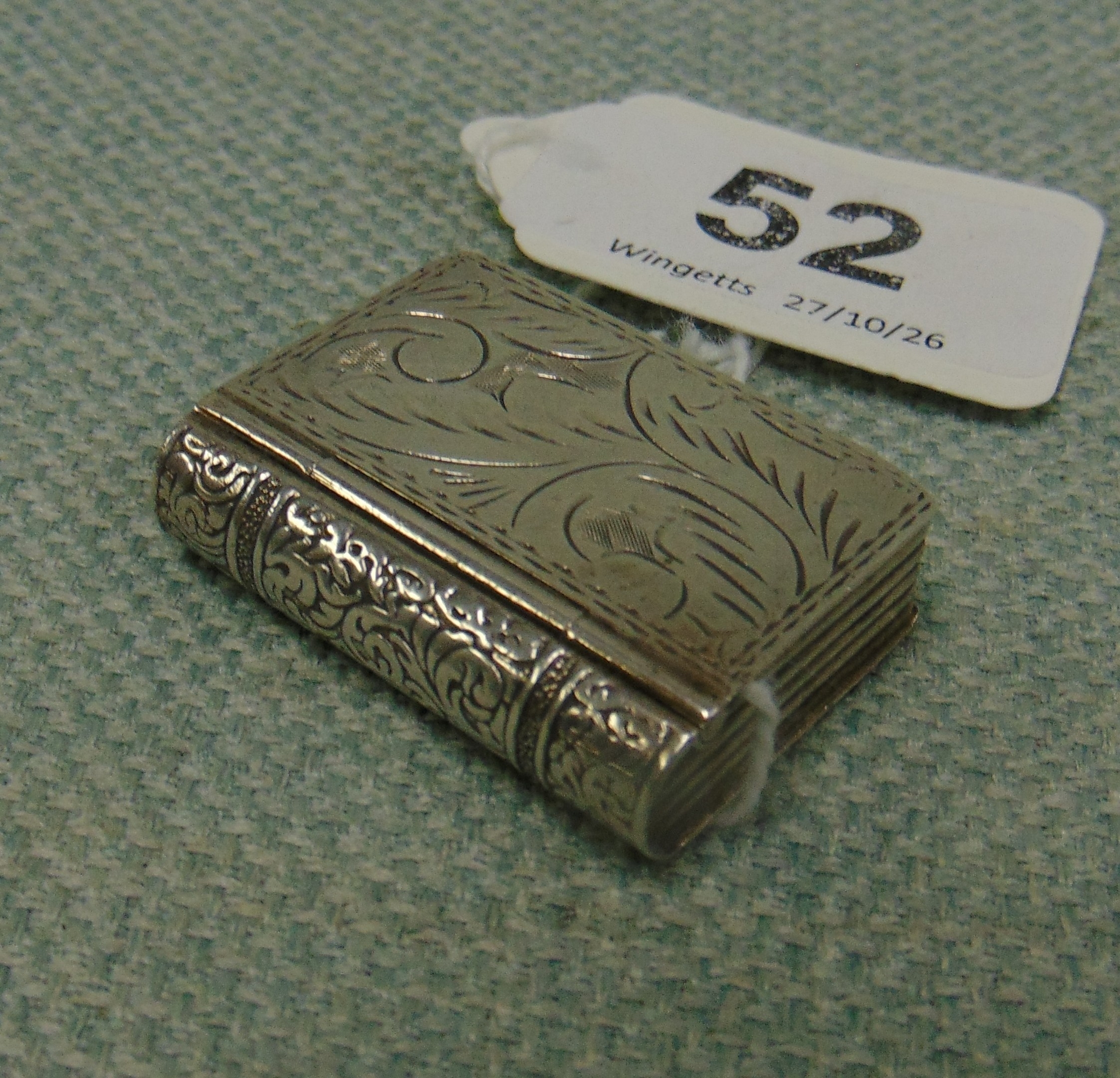Silver book form stamp holder, having engraved decoration.