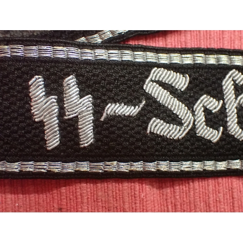 190 - WW2 German SS Schule-Tolz cuff title

FINELY WOVEN ALUMINIUM WIRE WORK SCRIPT. FOLDED AND STITCHED E... 