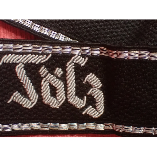 190 - WW2 German SS Schule-Tolz cuff title

FINELY WOVEN ALUMINIUM WIRE WORK SCRIPT. FOLDED AND STITCHED E... 
