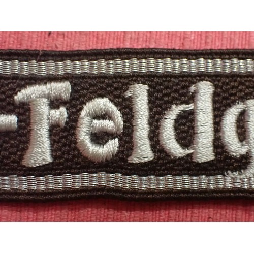 13 - WW2 SS-Feldgendarmerie cuff title

Aluminium wirework edging. The script is in a grey-silver-coloure... 