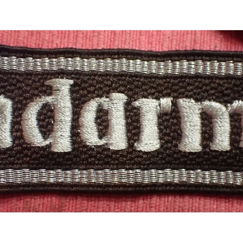 13 - WW2 SS-Feldgendarmerie cuff title

Aluminium wirework edging. The script is in a grey-silver-coloure... 