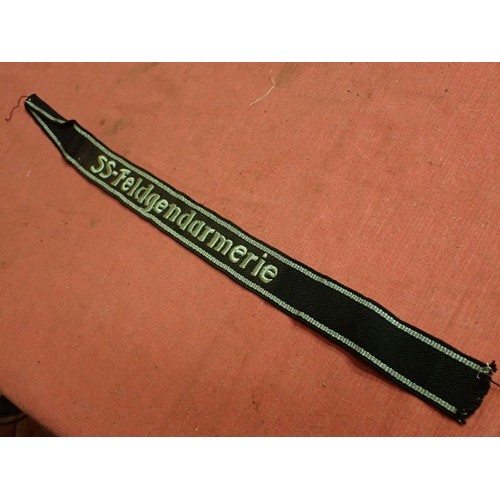 13 - WW2 SS-Feldgendarmerie cuff title

Aluminium wirework edging. The script is in a grey-silver-coloure... 