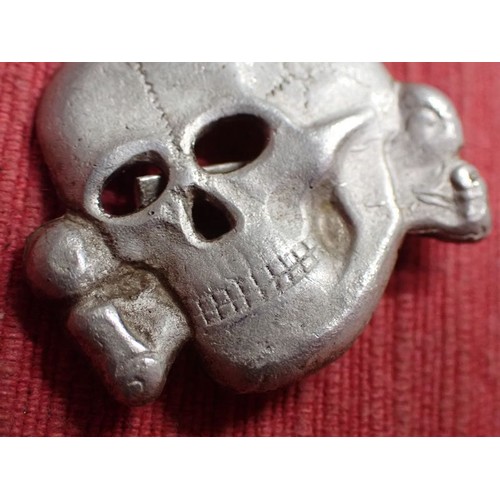 52 - WW2 German SS visor cap death's head badge

Die-stamped aluminium totenkopf. Untouched with a light ... 