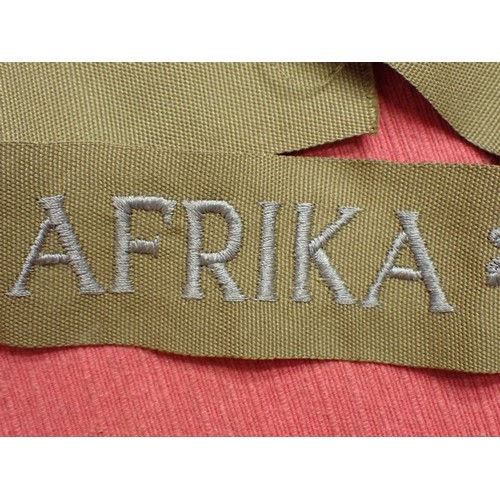 48 - WW2 German army AFRIKA cuff title

Thick grey/blue stitched script. The band is 435 mm long. Very go... 